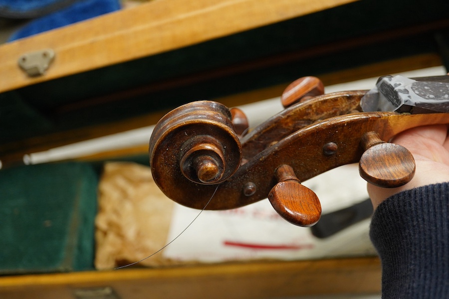 Four cased violins; an early 20th century violin, body 36cm, fitted with a microphone pick up taking a quarter inch jack plug, an early 20th century half size violin, body 32cm, and two student violins. Condition - poor